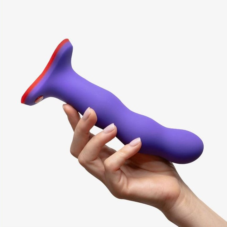 Bouncer Shake dildo in paars siliconen vastgehouden in hand met zuignapbasis
