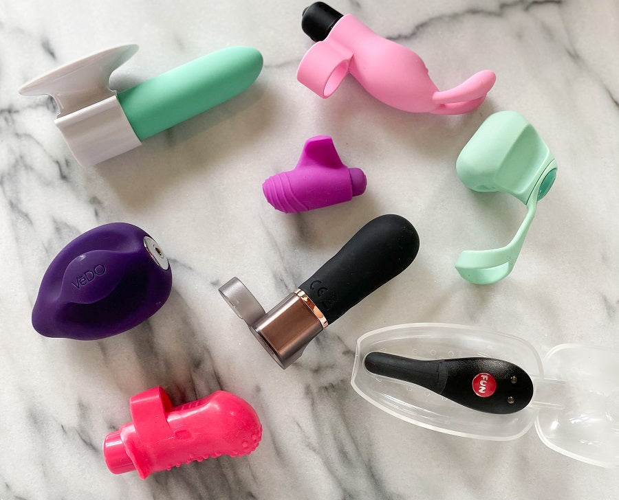 Verzameling compacte vingervibratoren en mini-vibrators in diverse kleuren en vormen op marmeren achtergrond