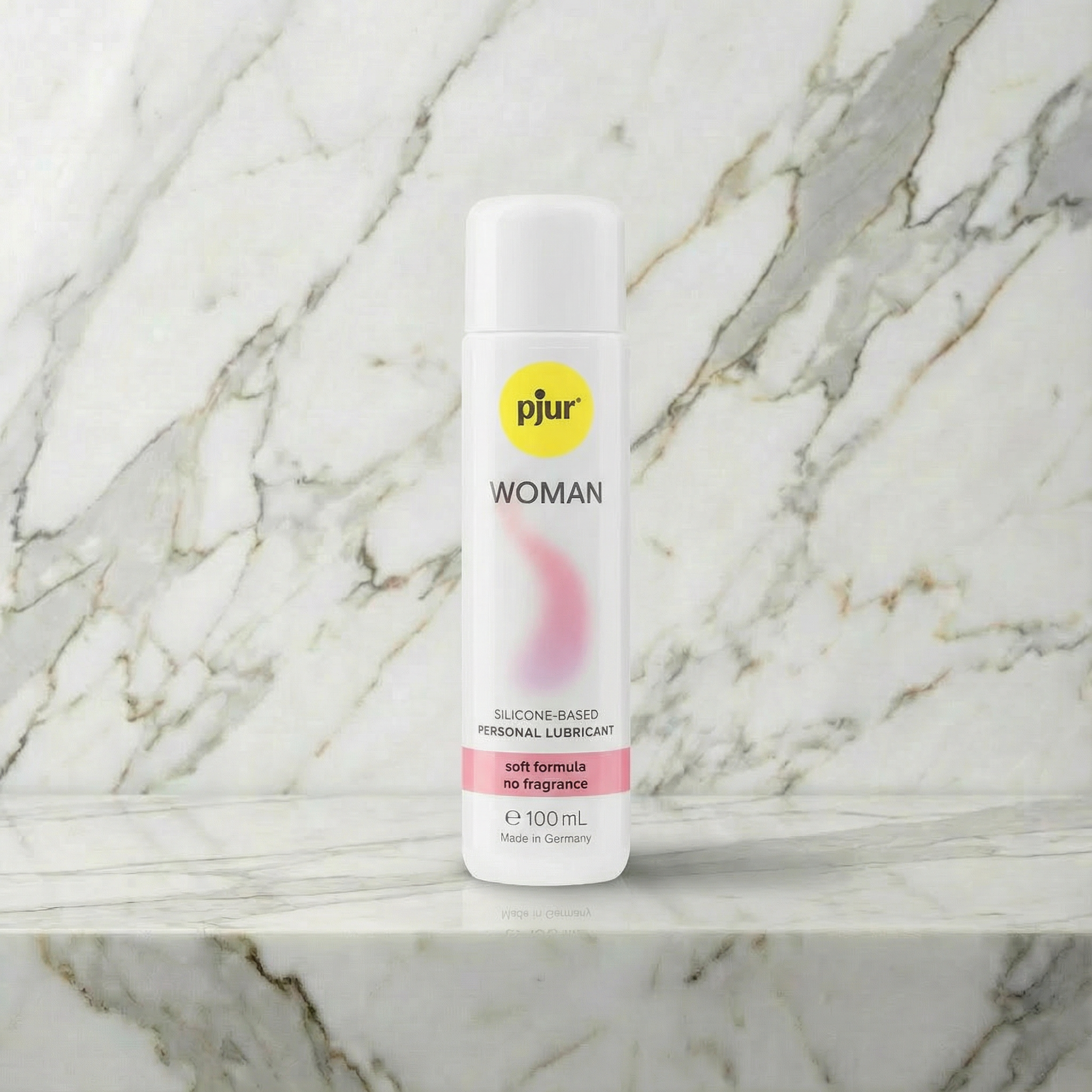 pjur Woman siliconenbasis glijmiddel 100 ml met roze accent op marmeren plank en achtergrond
