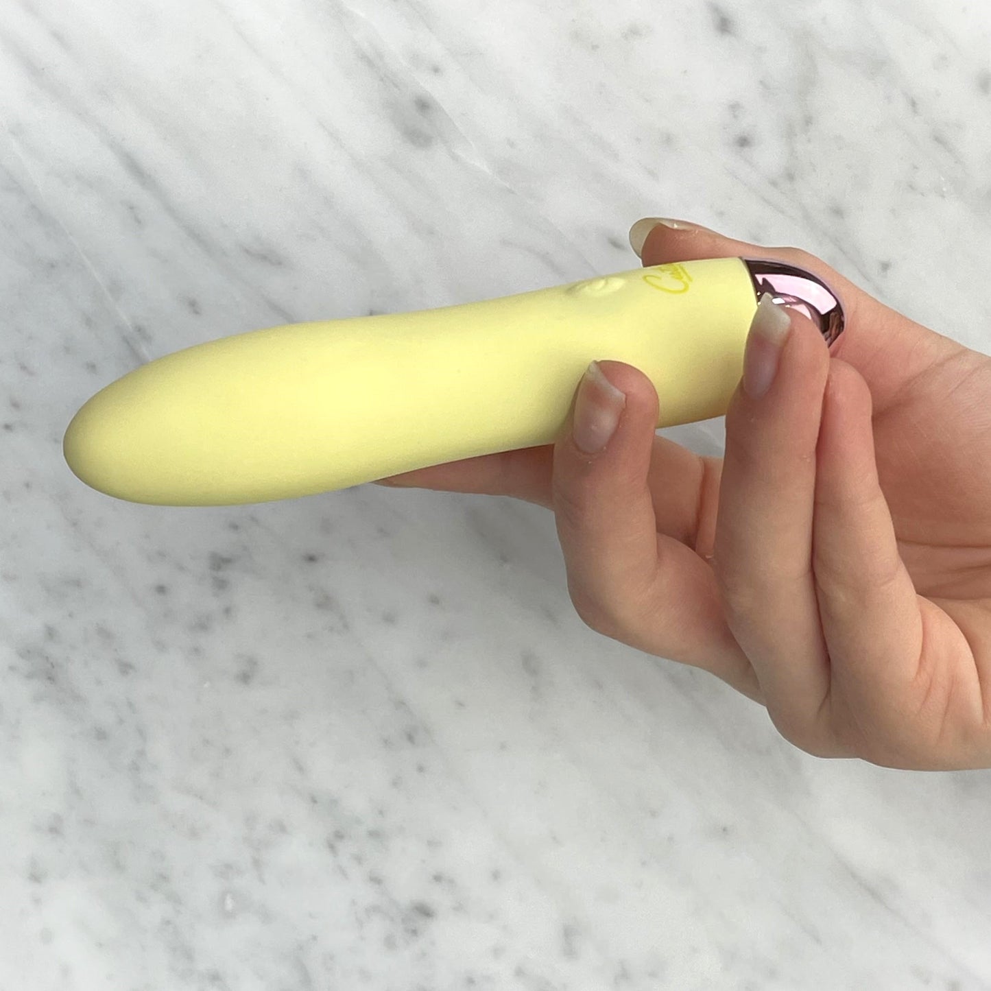 Elegante presentatie van de Cuties mini vibrator in stijlvolle wellness setting