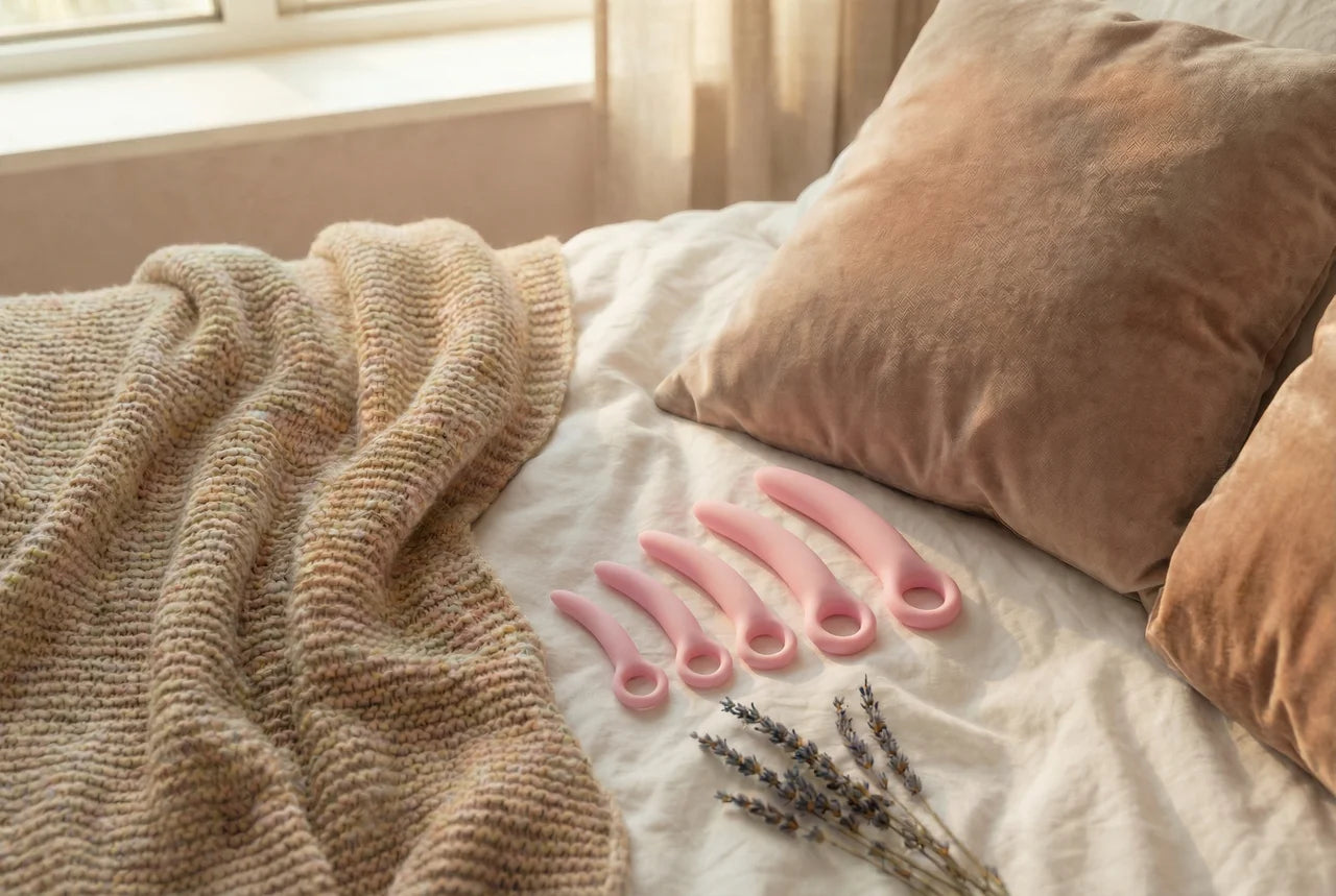 Siliconen dilator set op wit laken naast lavendel en zachte kussens in warm daglicht