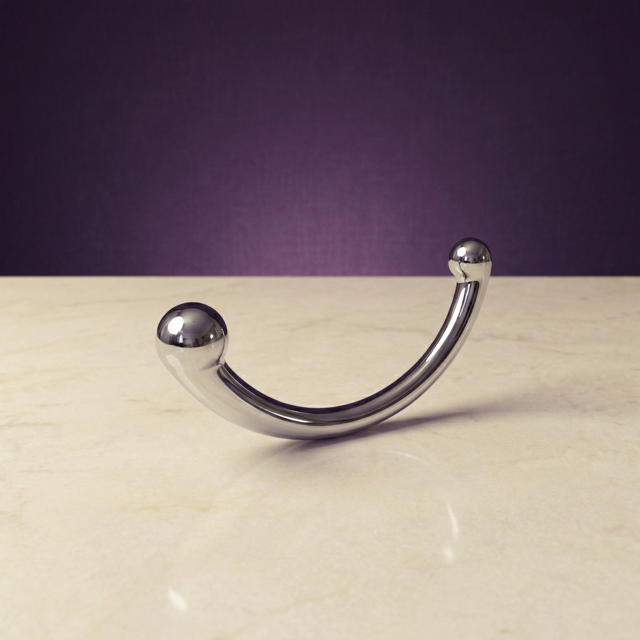 Zijaanzicht van glanzende metalen Joy wand met ergonomische vorm voor intiem gebruik