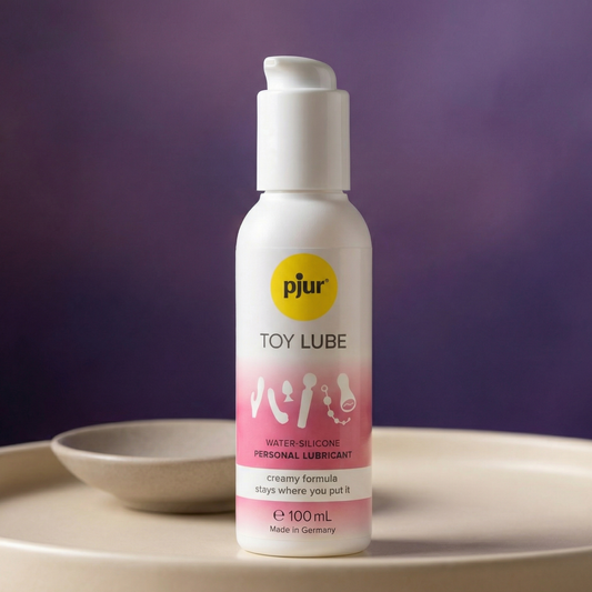 pjur Toy Lube 100 ml flesje op beige schaaltje met paarse achtergrond