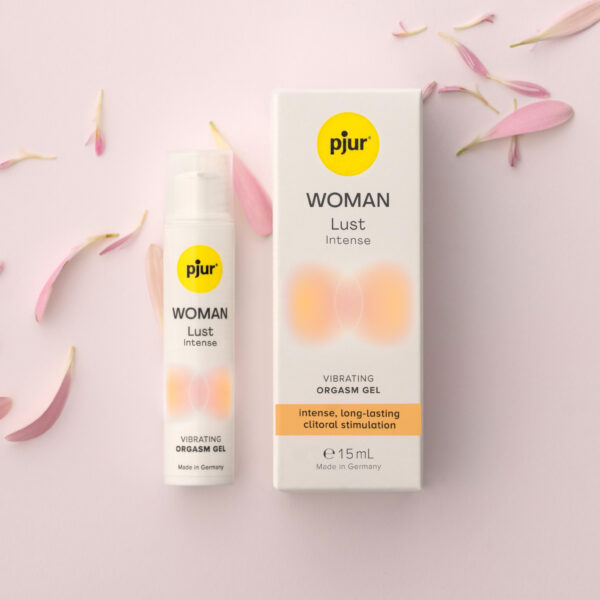 pjur Woman Lust Intense flacon en verpakking op roze achtergrond omringd door roze bloemblaadjes