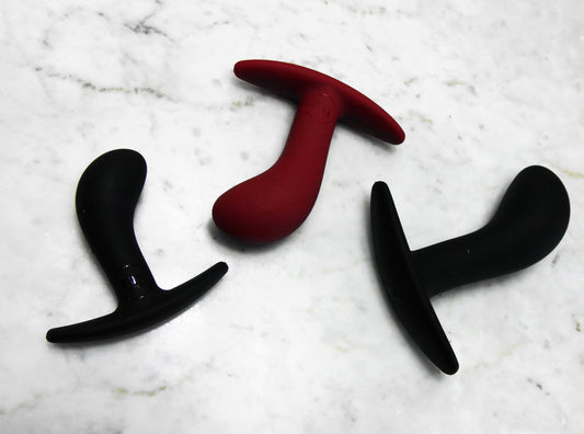 Fun Factory Bootie buttplug set van drie uitgespreid op marmeren ondergrond