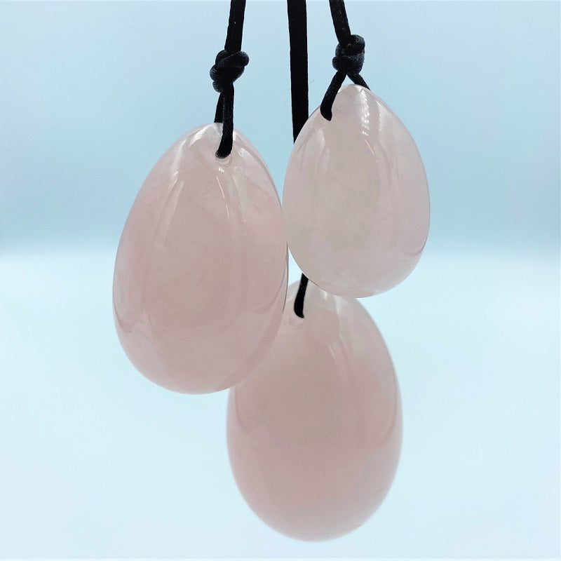 Elegante styling van rozenkwarts yoni eitjes set met zachte verlichting en natuurlijke elementen
